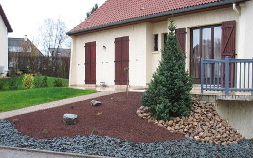 Massif minéral devant une maison : pouzzolane rouge, ardoise concassée, galets et conifère